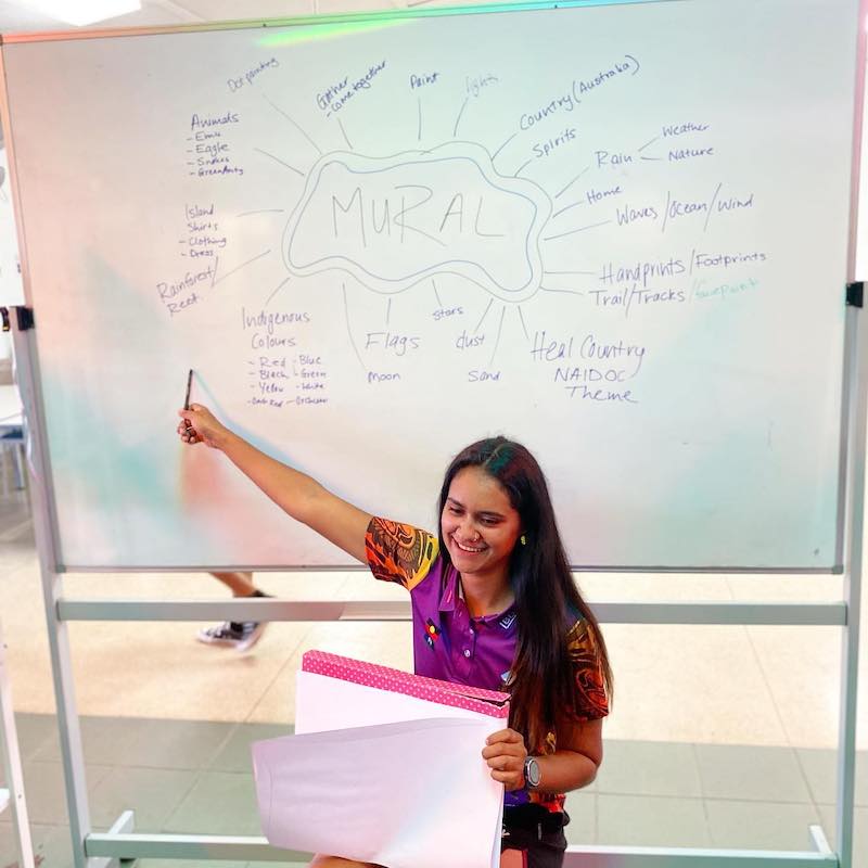 Jess in front of white board during a brainstorming session